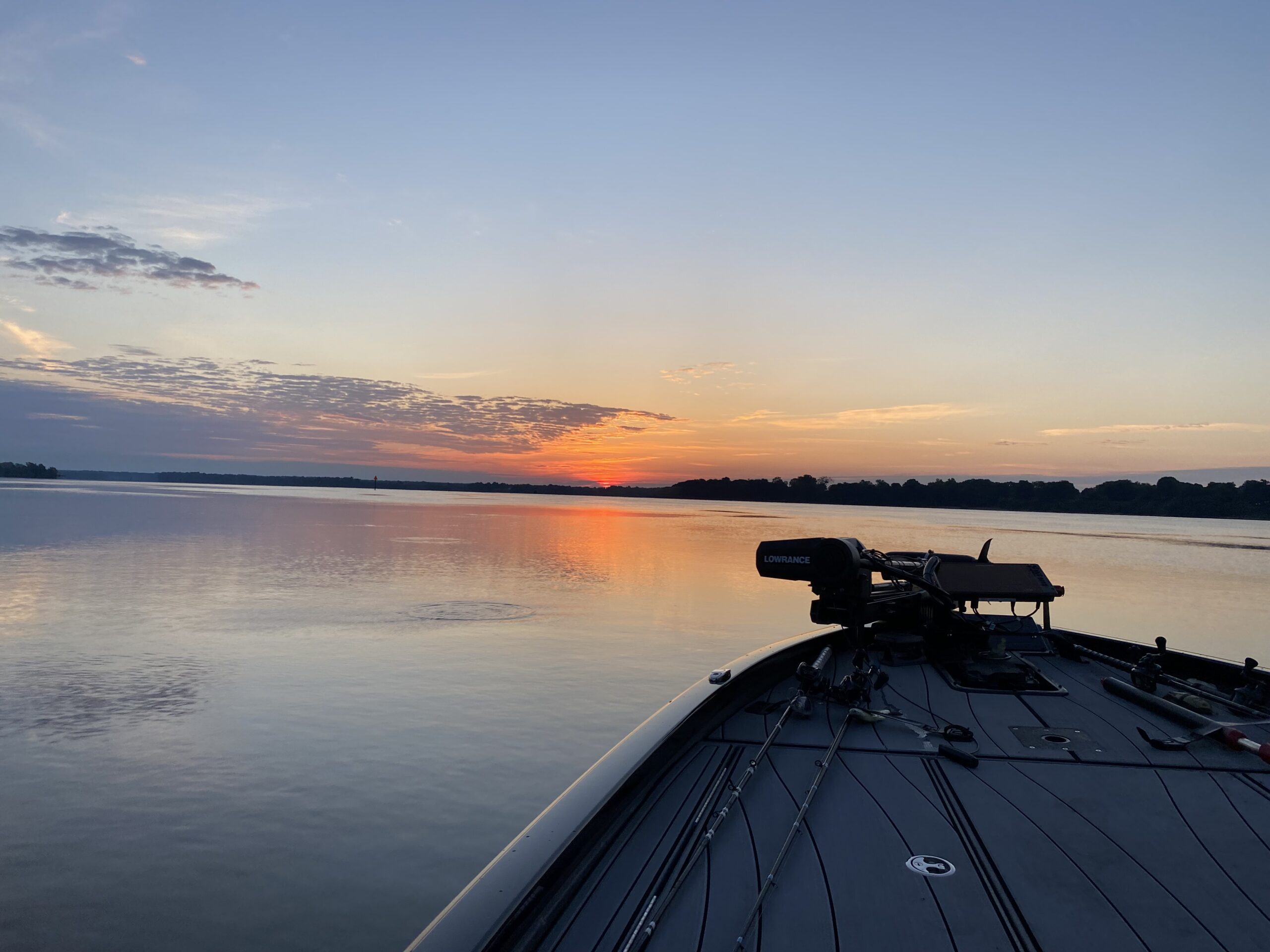 Fishing boat on calm water at sunset